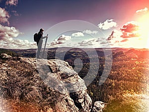 Climber outstretched on mountain top looking at landscape