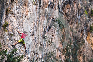 Climber overcomes a difficult climbing route on a natural terrain