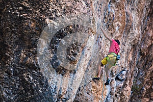Climber overcomes a difficult climbing route on a natural terrain