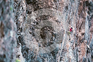 Climber overcomes a difficult climbing route on a natural terrain