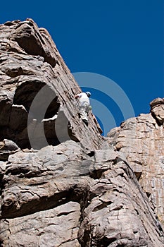 Climber reaching top of climb