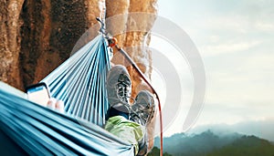 Climber resting in hammock on the vertical cliff wall