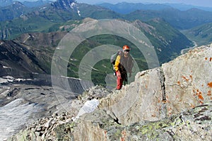 Climber with the rope on stone summit