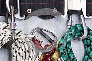 Climber`s belt with different ropes and carbines for insurance lie on a light background, close-up