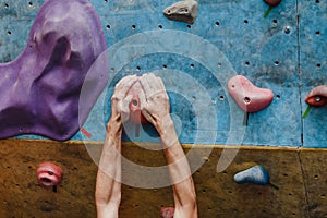 Climber`s hand on the climbing wall hook close-up