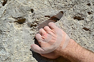 Climber`s hand holding on to rock