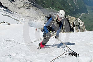 Climber on snow summit, rocky mountain peaks and glacier