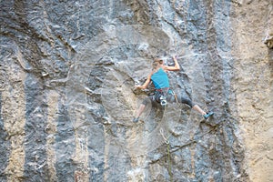 The climber is training to climb the rock.