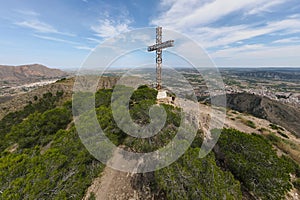 A climber under the summit cross in Spain