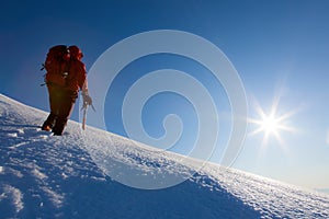 Climber walks on a glacier. Winter season, clear sky.