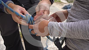 Climber woman preparing for climbing up the rocky wall rift by checking climbing equipment. Climbing extreme active