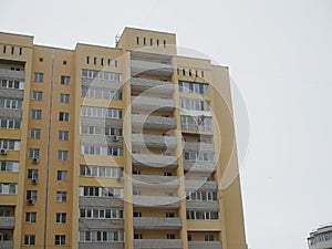 Climber worker hanging on ropes for balcony insulation of high rise building