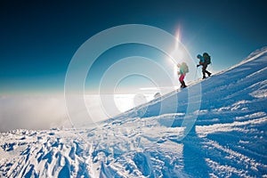 climbers climb the mountain. Winter mountaineering. two girls in snowshoes walk through the snow