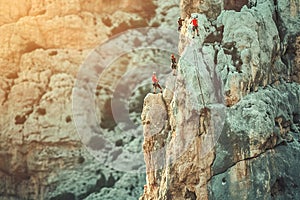 Climbers conquering challenging rock formations in mountain.