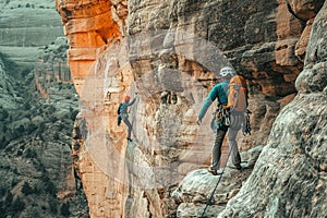 Climbers conquering challenging rock formations in mountain.