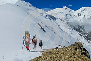 Climbers on glacier traver mountain route attached to the alpinist rope