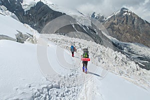 Climbers on glacier traver mountain route attached to the alpinist rope