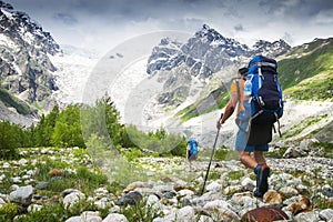 Climbers with hiking backpacks go to the mountain. hikers in mountains. Tourists hike on rocky mounts photo