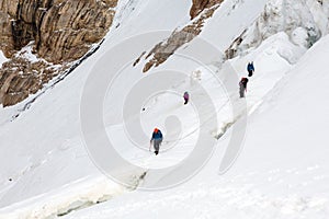 Climbers Linked with Protection Rope Ascending Glacier