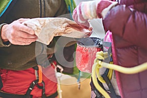 Climbers preparing to climb, pour chalk into the bag