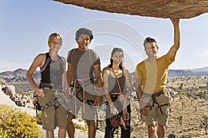 Climbers standing Underneath Rock photo