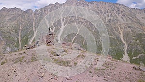 Climbers stopped to rest in mountains. Clip. Tourists on ascent to mountains stopped to rest on rocky ledge