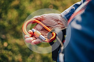 Climbing carabiner cliped or connected to a climbing harness. Climber wearing a harness with biner a