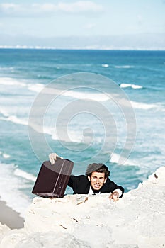 Climbing cliff, problem or businessman with stress for job, career opportunity or work crisis at beach. Professional