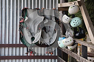 Climbing equipment - colorful helmets and safety vests hanging on a board in a rope park