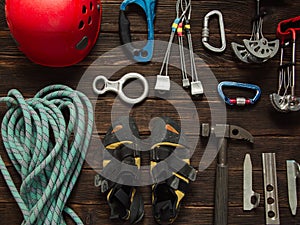 Climbing equipment on dark wooden background, top view