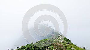 Climbing a group of tourists on mountain in fog. Mountain top,