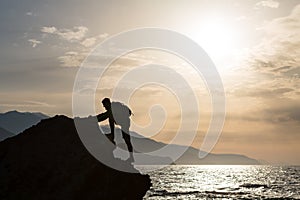 Climbing hiking silhouette in mountains and ocean