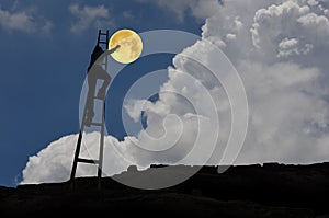 Man on stairs and full moon in blue sky