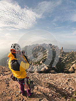 climbing person taking pictures of Montserrat at sunset