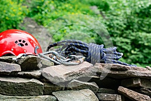 Climbing sport tools: hard hat, rope, carabiner. Mountaineering equipment on rocks