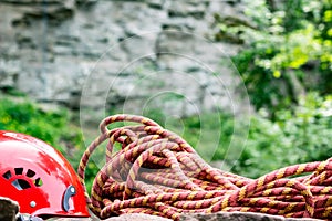Climbing sport tools: hard hat, rope, carabiner. Mountaineering equipment on rocks