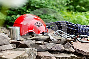 Climbing sport tools: hard hat, rope, carabiner. Mountaineering equipment on rocks