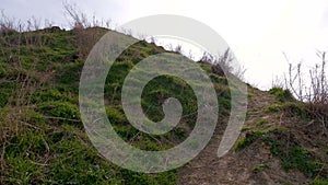 Climbing up the green hill in cloudy weather