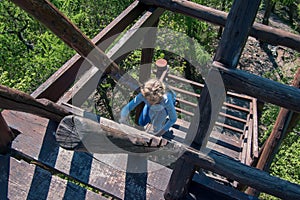 Climbing up by wooden steps in the natural observation tower