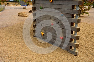 Climbing wall on the playground in the park. solid beams with climbing handles in the form of colored stones made of composite mat