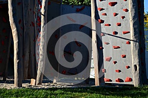 Climbing wall on the playground in the park. solid beams with climbing handles in the form of colored stones made of composite mat