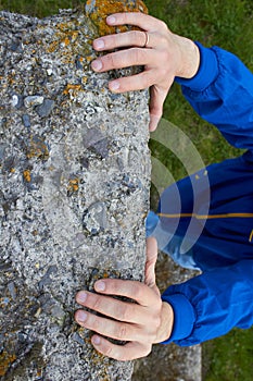 Climbs the rock with his hands,Rock climber`s hand grasping handhold on natural cliff
