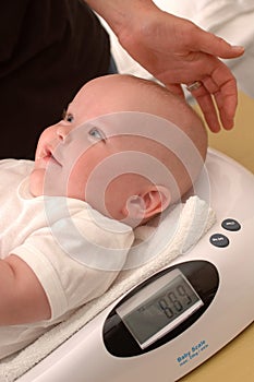 Clinic nurse weighing a baby