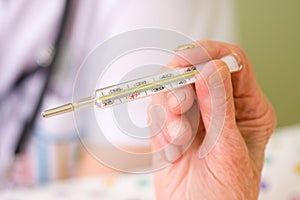 Clinical thermometer in elderly hands