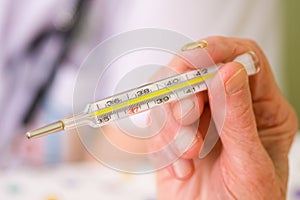 Clinical thermometer in elderly hands