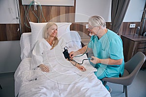 Clinician conducting physical examination of patient using sphygmomanometer