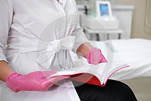 Clinician in White Uniform Reviewing a Medical Schedule photo