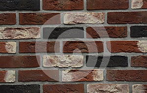 Clinker bricks background. A close-up of a clinker brick wall from dark red, white, orange and black bricks photo