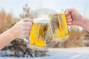 Clinking Beer glasses on winter.