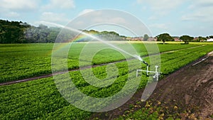 clip of agricultural irrigation system spraying water on arable crops